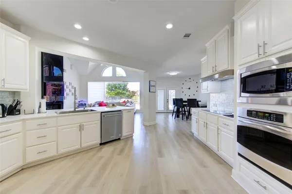a large white kitchen with kitchen island a sink a stove and refrigerator