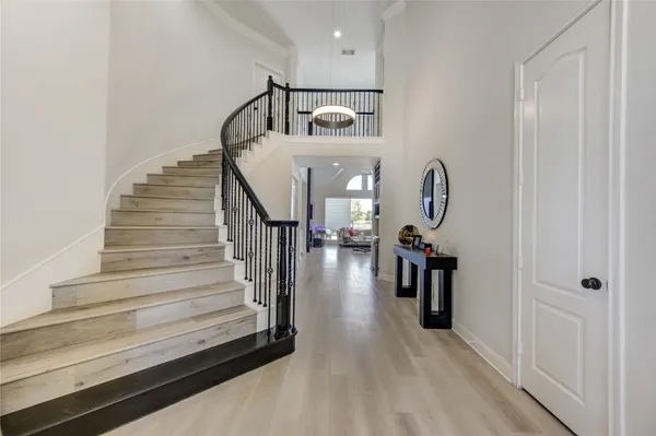 a view of entryway and hall with wooden floor