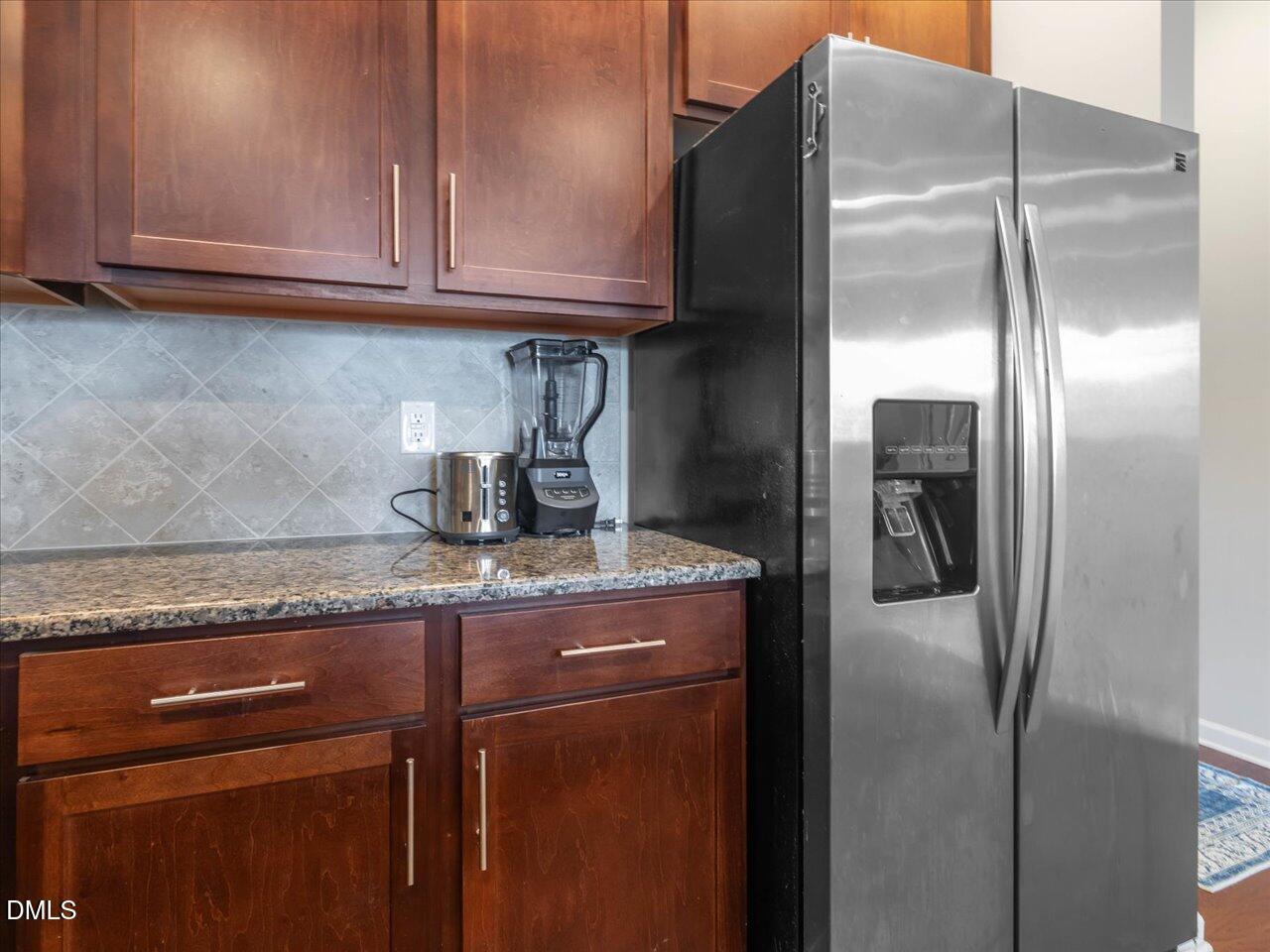 409 Provincial Street Raleigh, NC 27603 - Photo 12 of 44 a kitchen with granite countertop a refrigerator and cabinets