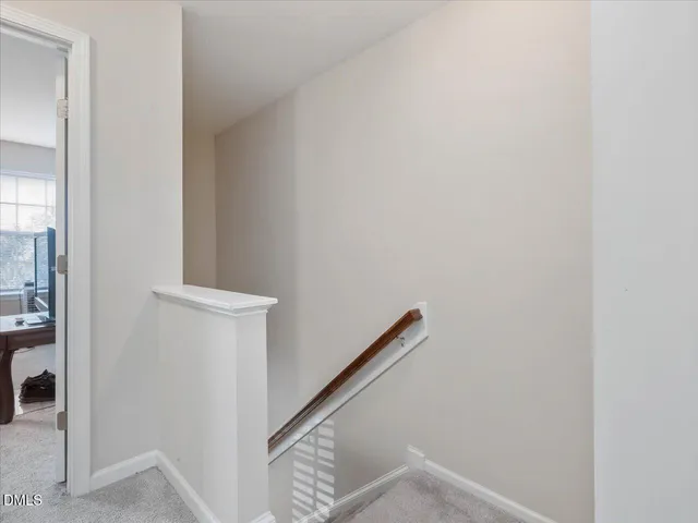 a view of staircase with wooden floor and white walls
