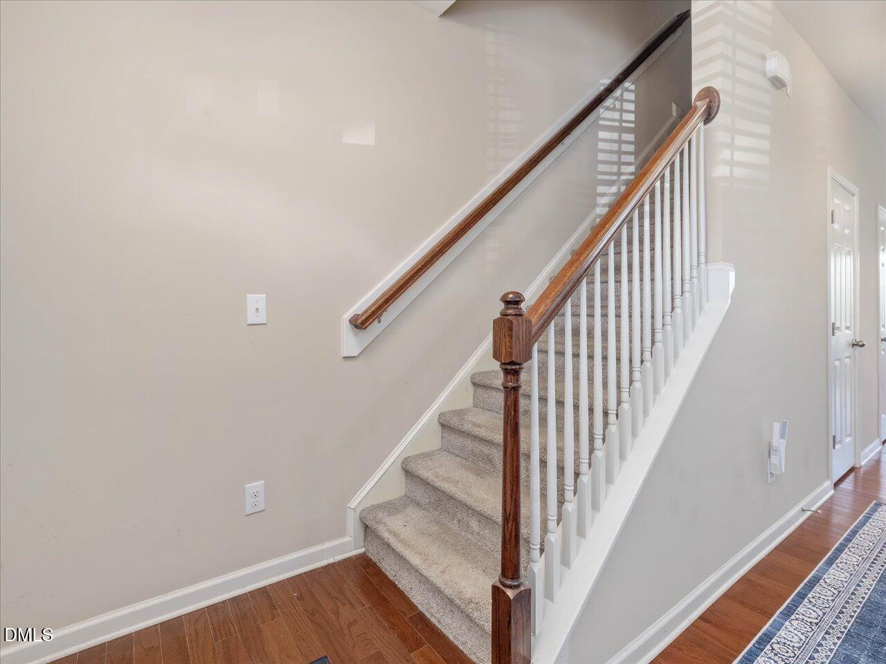 409 Provincial Street Raleigh, NC 27603 - Photo 22 of 44 a view of staircase with wooden floor and white walls