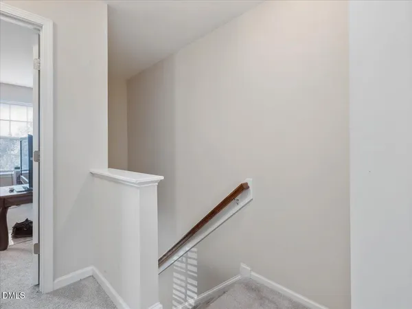 a view of staircase with wooden floor and white walls
