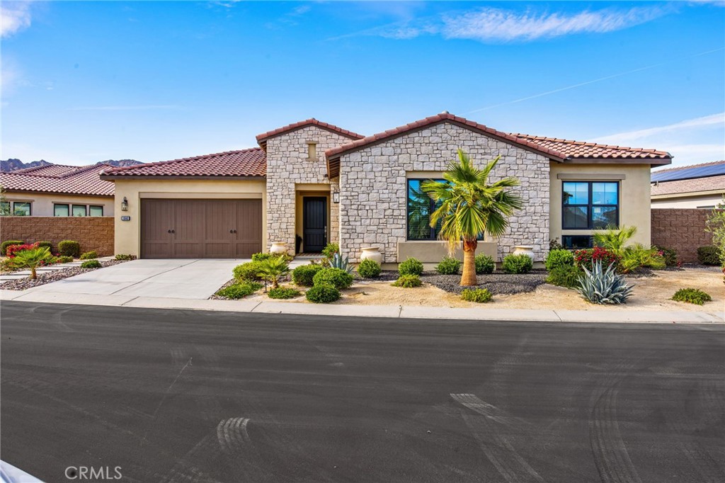 80440 Old Ranch Trail South La Quinta, CA 92253 - Photo 34 of 46 a front view of a house with a yard and a garage