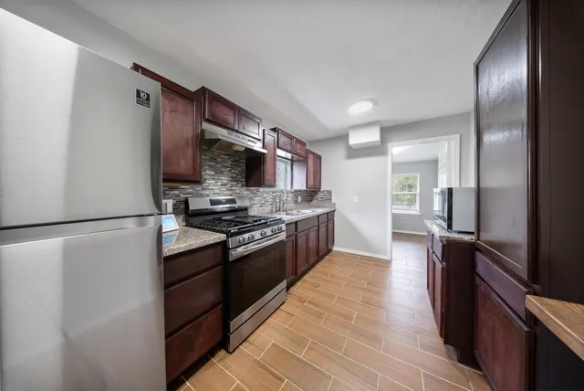 a kitchen with stainless steel appliances granite countertop a refrigerator stove and oven