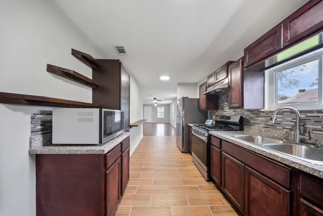 a large kitchen with stainless steel appliances kitchen island a large counter space a sink and cabinets