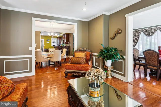 a living room with furniture and a dining table with wooden floor