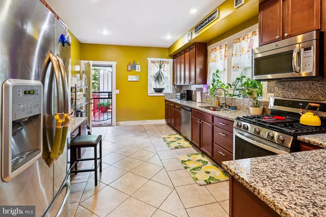 a kitchen with stainless steel appliances kitchen island granite countertop a stove a sink and a microwave