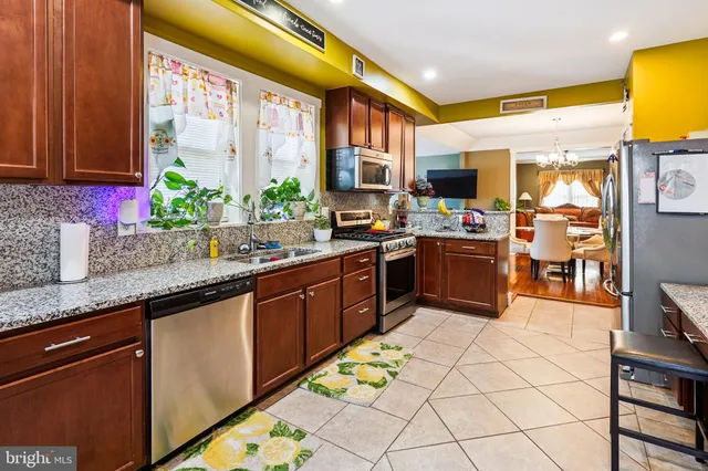 a kitchen with stainless steel appliances granite countertop sink stove and cabinets