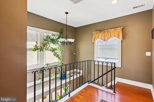 a view of a hallway with wooden floor and windows
