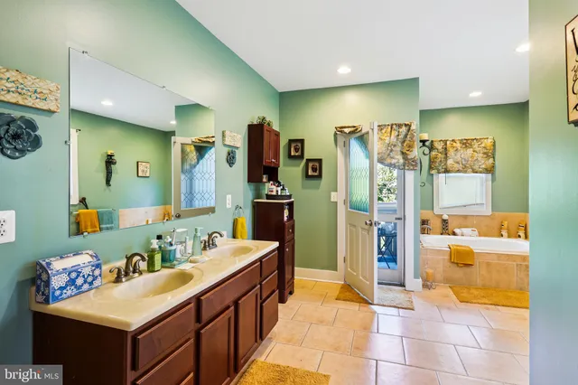 a bathroom with a tub sink and mirror