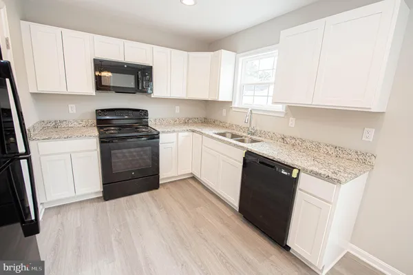 a view of hallway with granite countertop wooden floor