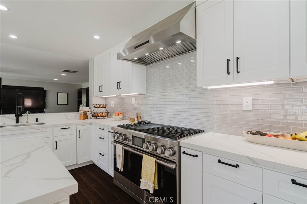 32480 The Old Road Castaic, CA 91384 - Photo 24 of 68 a kitchen with stainless steel appliances a sink dishwasher and white cabinets with wooden floor