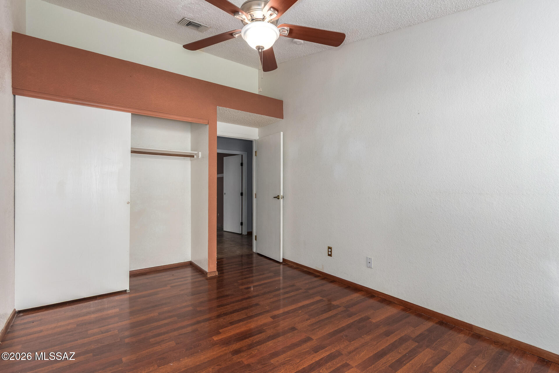 5331 West Eaglestone Loop Tucson, AZ 85742 - Photo 23 of 35 an empty room with wooden floor chandelier fan and closet area