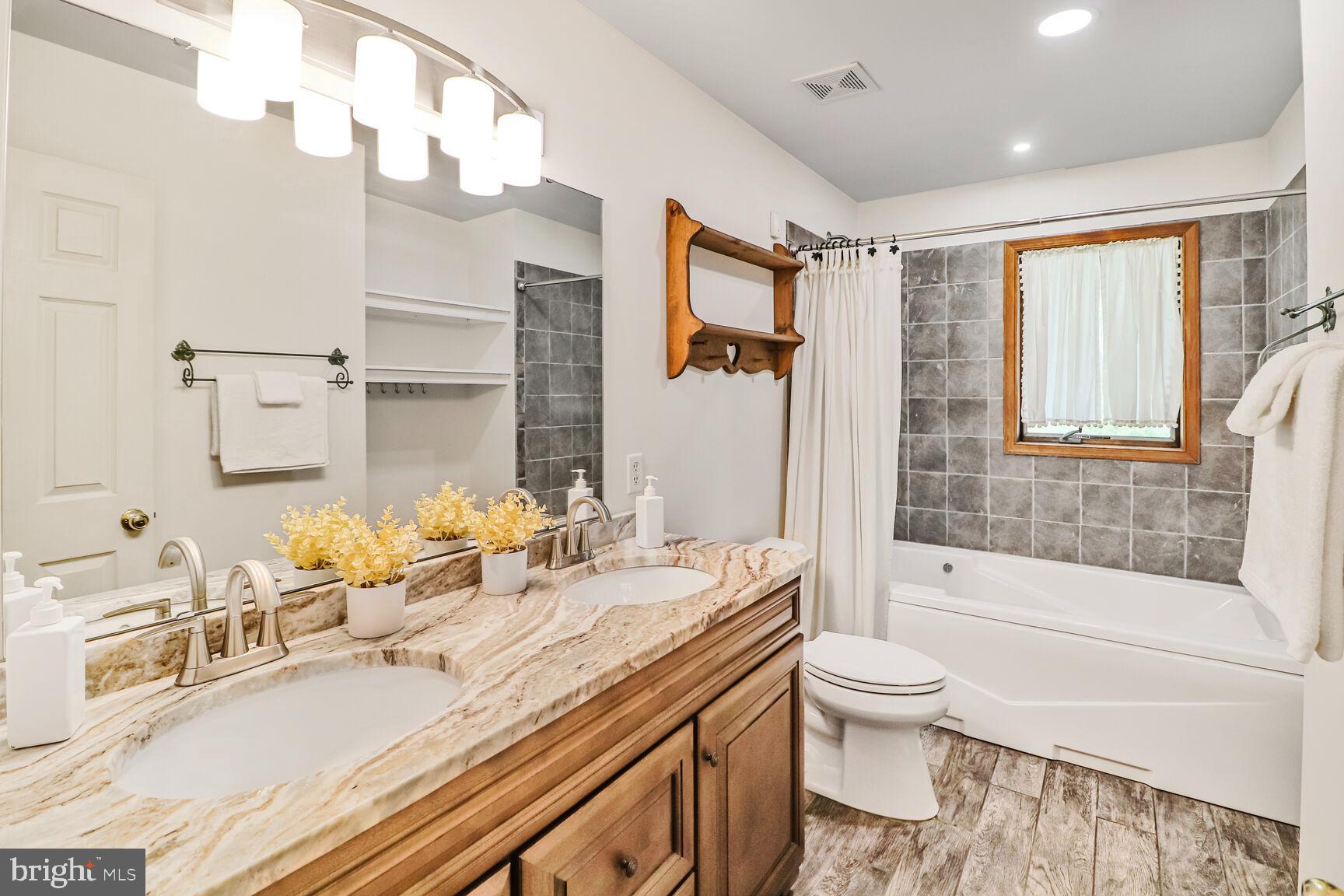 989 Ridge Road Finksburg, MD 21048 - Photo 14 of 50 a bathroom with a granite countertop sink mirror vanity bathtub and toilet
