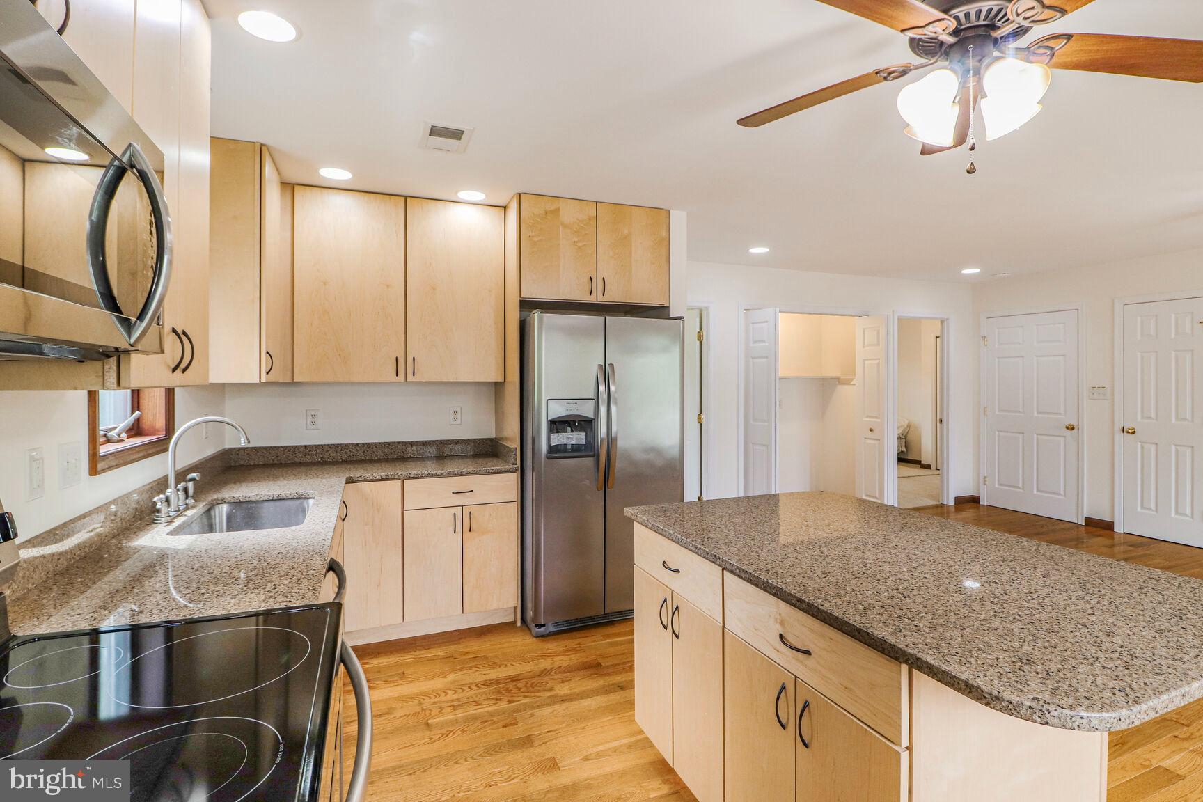 989 Ridge Road Finksburg, MD 21048 - Photo 46 of 50 a kitchen with stainless steel appliances granite countertop a sink a stove and a refrigerator