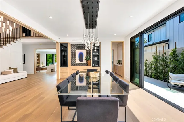a dining room with furniture potted plants and wooden floor