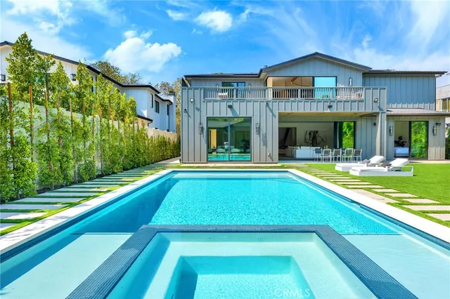 a bathroom with a tub a sink and a large mirror