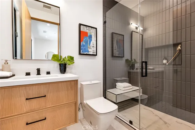 a bathroom with a granite countertop sink mirror and toilet