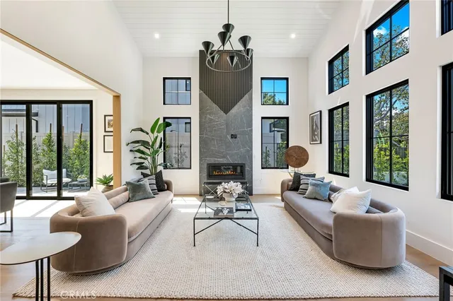 a large kitchen with stainless steel appliances kitchen island a stove a sink a refrigerator and white cabinets with wooden floor