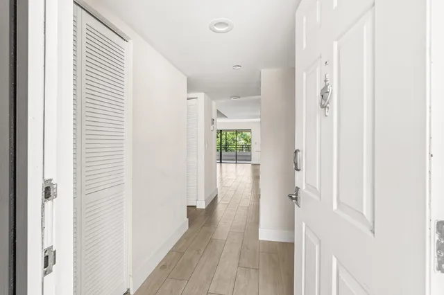 a view of a hallway with wooden floor and staircase