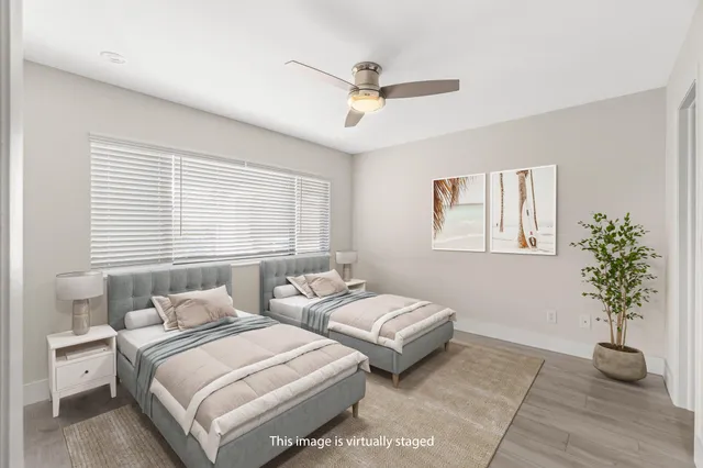 a bedroom with two beds and a potted plant