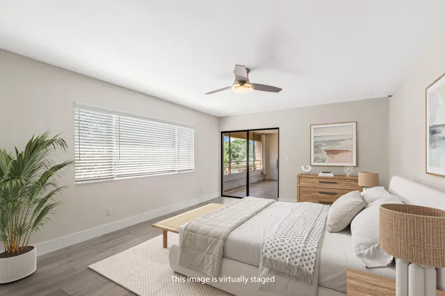 a bedroom with a large bed and wooden floor