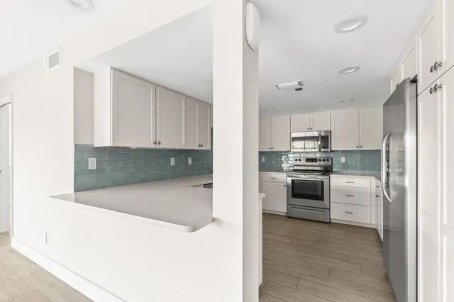 a kitchen with cabinets and stainless steel appliances