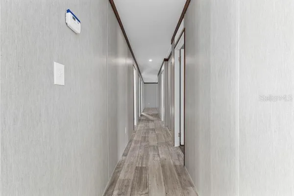 a view of a hallway with wooden floor and staircase