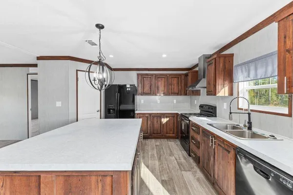 a kitchen with sink a refrigerator and wooden cabinets