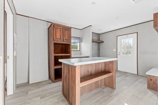 a kitchen with kitchen island wooden cabinets and refrigerator