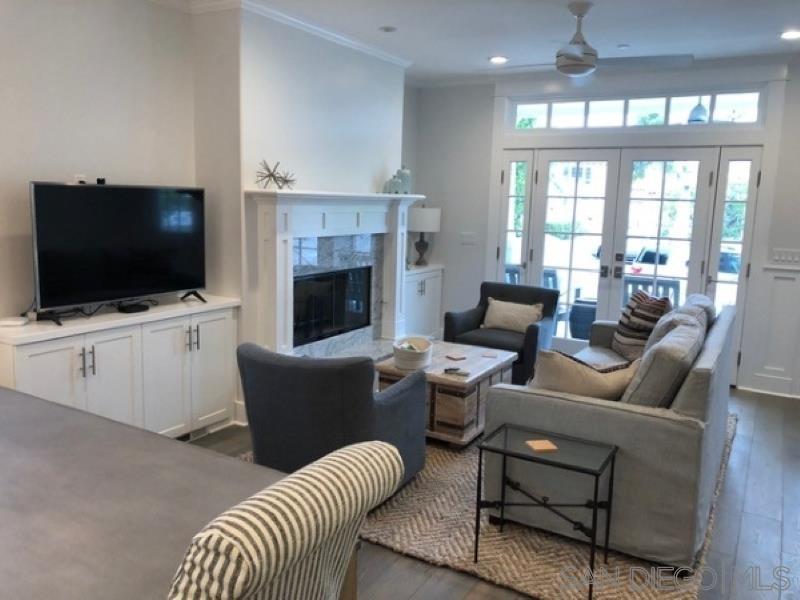 453 E Avenue Coronado, CA 92118 - Photo 4 of 16 a living room with furniture a flat screen tv and a fireplace