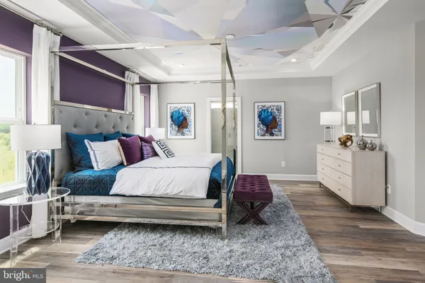 a bedroom with a bed wooden floor and window