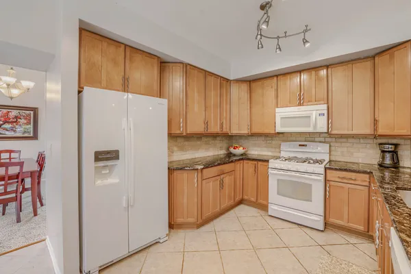 a kitchen with stainless steel appliances granite countertop a refrigerator sink and cabinets