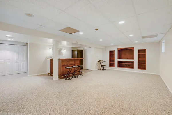 a view of an empty room with closet and windows