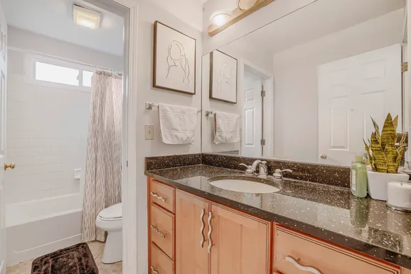 a bathroom with a granite countertop sink toilet and shower