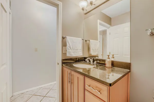 a bathroom with a granite countertop sink and a mirror