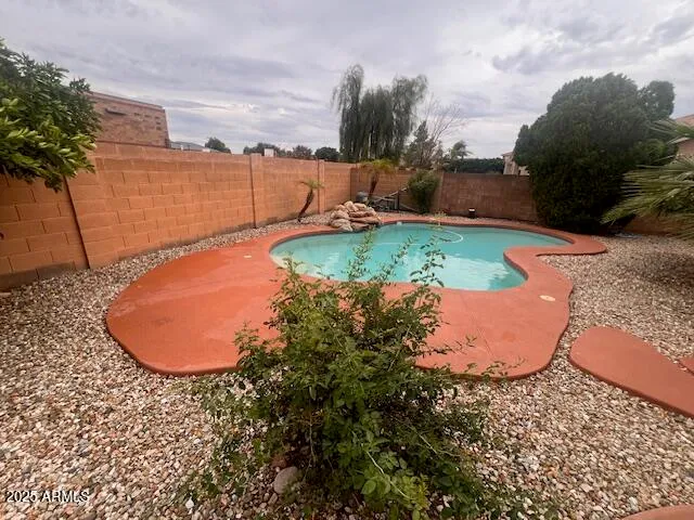 a view of a swimming pool with a yard and outdoor seating