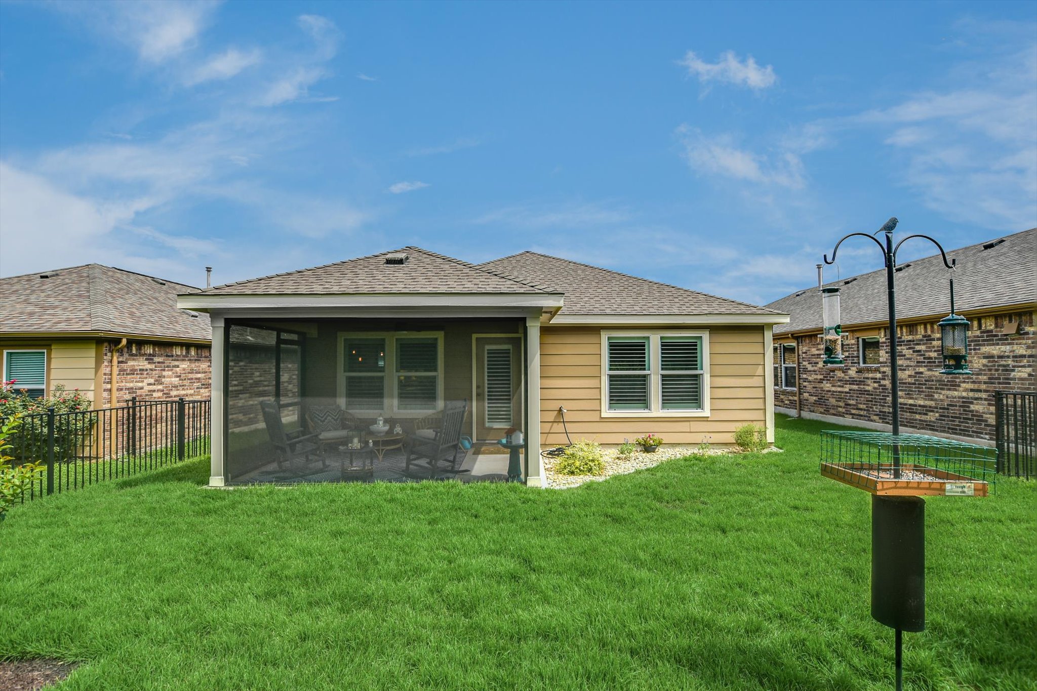 231 Hobby Street Georgetown, TX 78633 - Photo 27 of 29 A well-maintained yard embraces a dwelling with a welcoming screened patio, perfect for enjoying tranquil moments.