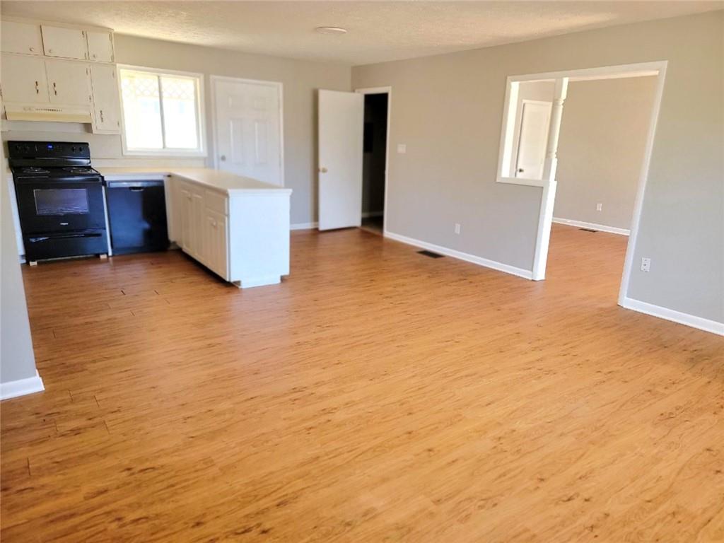a view of a kitchen with wooden cabinet and a stove top oven
