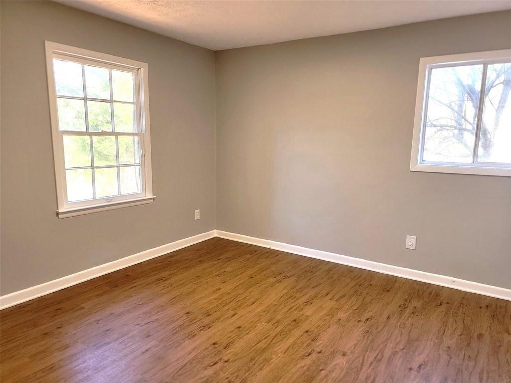 4042 Jodeco Road McDonough, GA 30253 - Photo 10 of 16 an empty room with wooden floor and windows