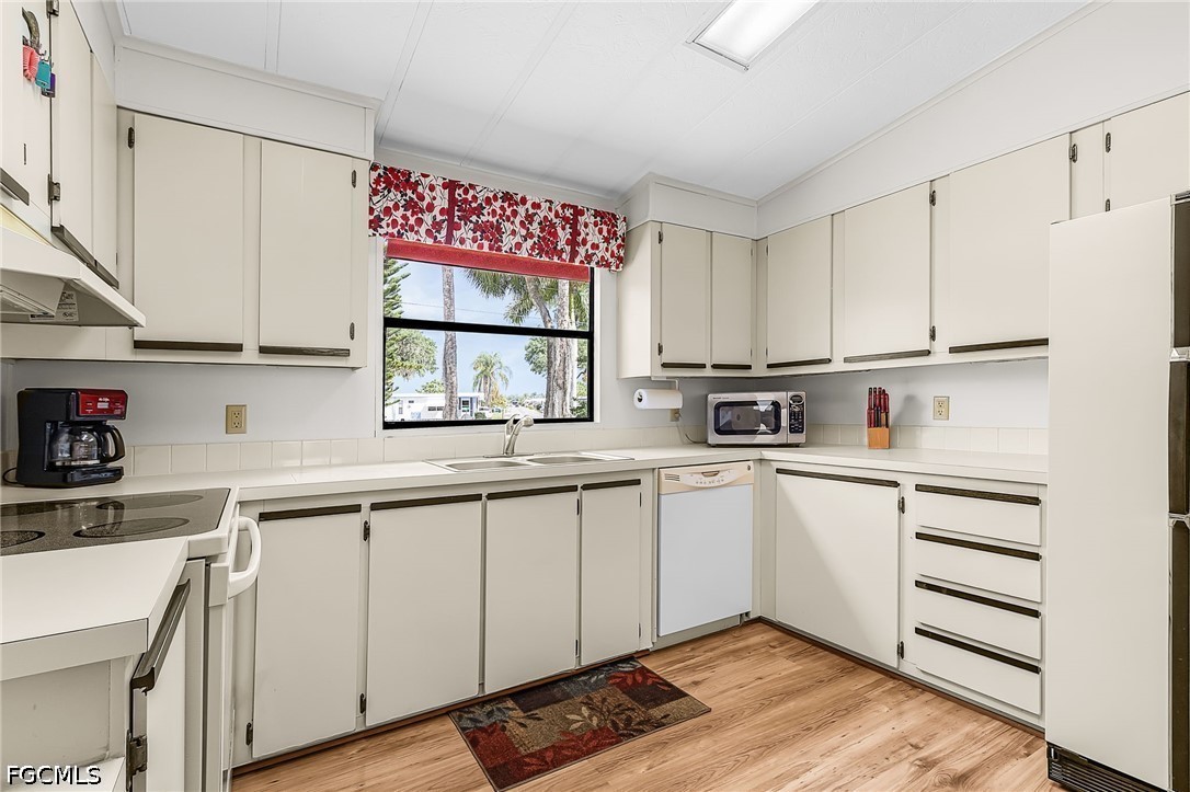 5 Erica Street Alva, FL 33920 - Photo 7 of 37 a kitchen with granite countertop white cabinets and white appliances