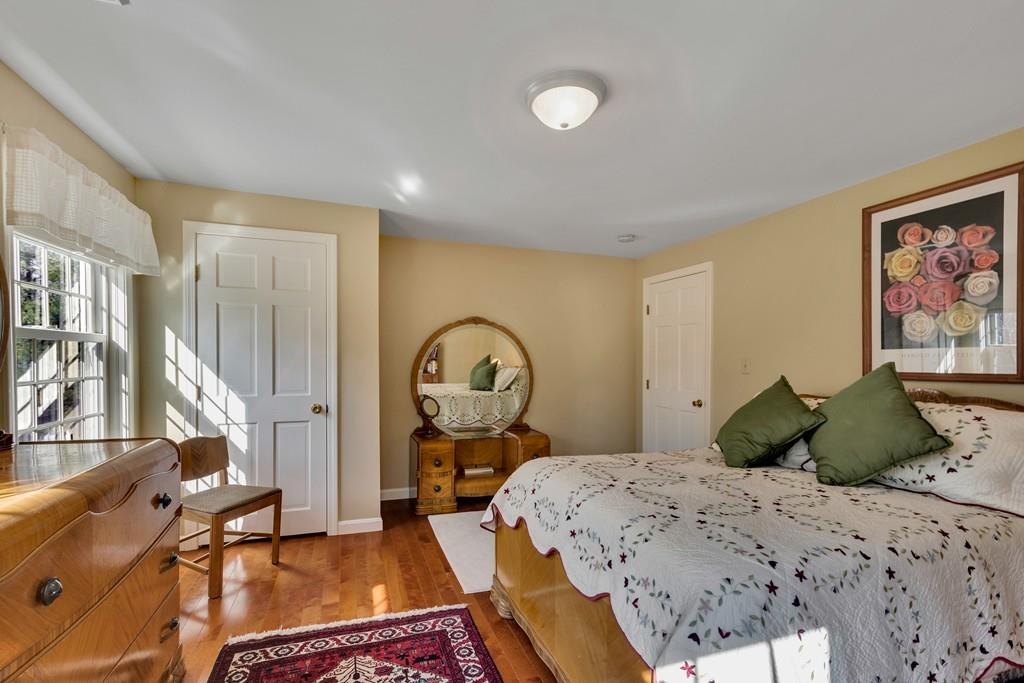 51 Parker Road Shirley, MA 01464 - Photo 21 of 39 a bedroom with a bed a mirror and a large window with garden view