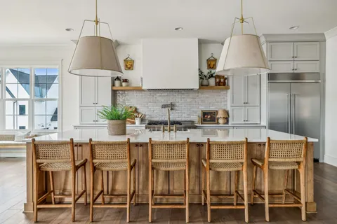a kitchen with granite countertop a table chairs stove and cabinets