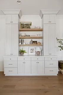 a view white cabinets with wooden floor