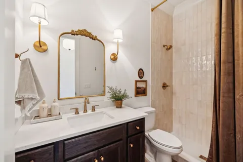 a bathroom with a granite countertop sink a toilet and a mirror