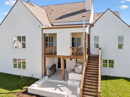 a view of a patio with couches table and chairs with wooden floor and fence