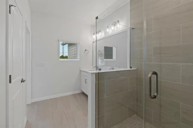 a bathroom with a sink a mirror and shower