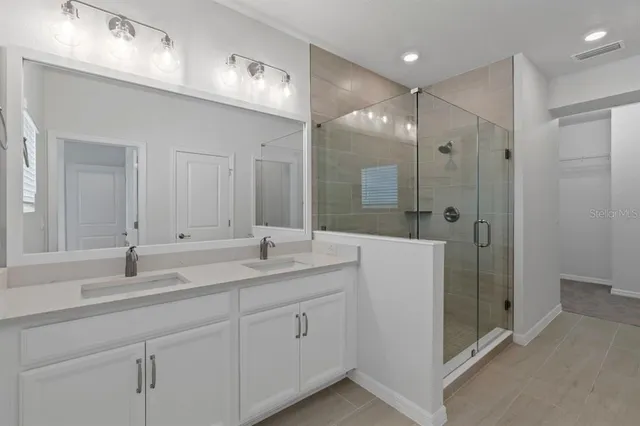a bathroom with double sink and a mirror