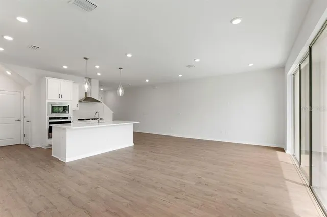 a view of kitchen with kitchen island stainless steel appliances sink refrigerator and microwave
