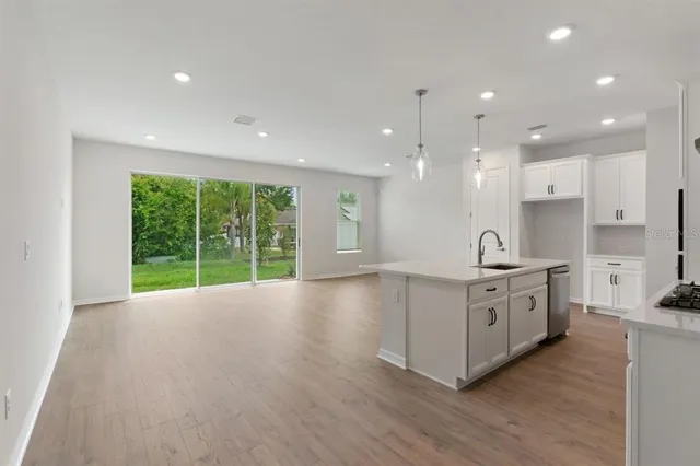 a large kitchen with stainless steel appliances granite countertop a large center island a stove a sink and a large window